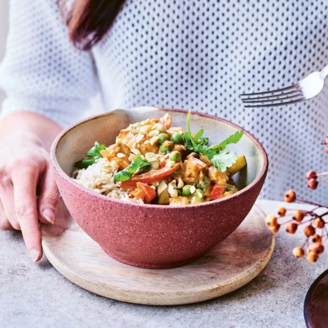 Kip in pindasaus met paprika, courgette en erwtjes